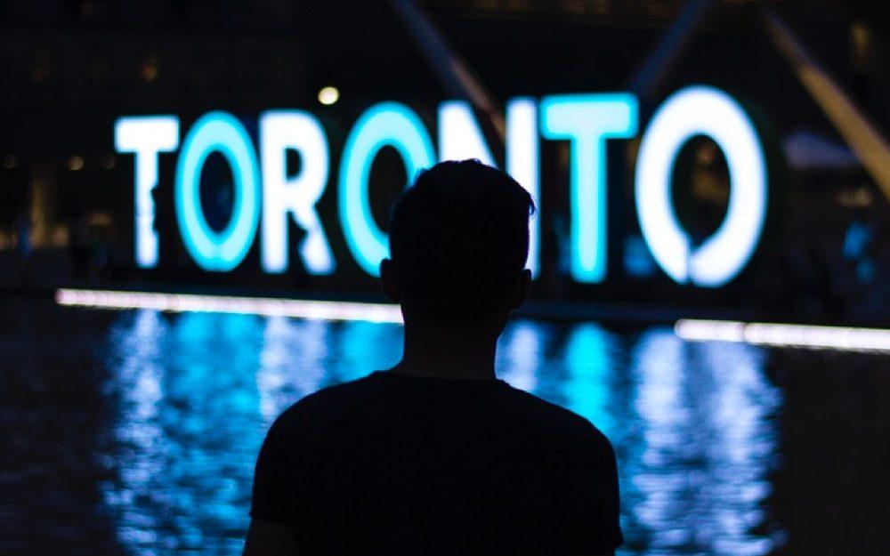 person standing in front of a Toronto sign