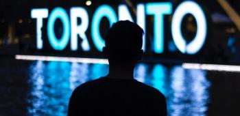 person standing in front of a Toronto sign