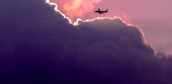 airplane flying over a purple sky