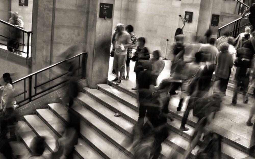 black and white blurry photo of people walking on stairs 