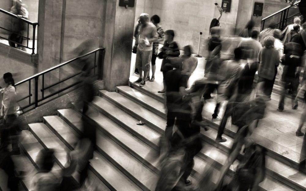 black and white blurry photo of people walking on stairs 