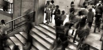 black and white blurry photo of people walking on stairs